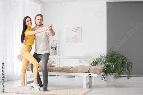 Happy young couple dancing at home