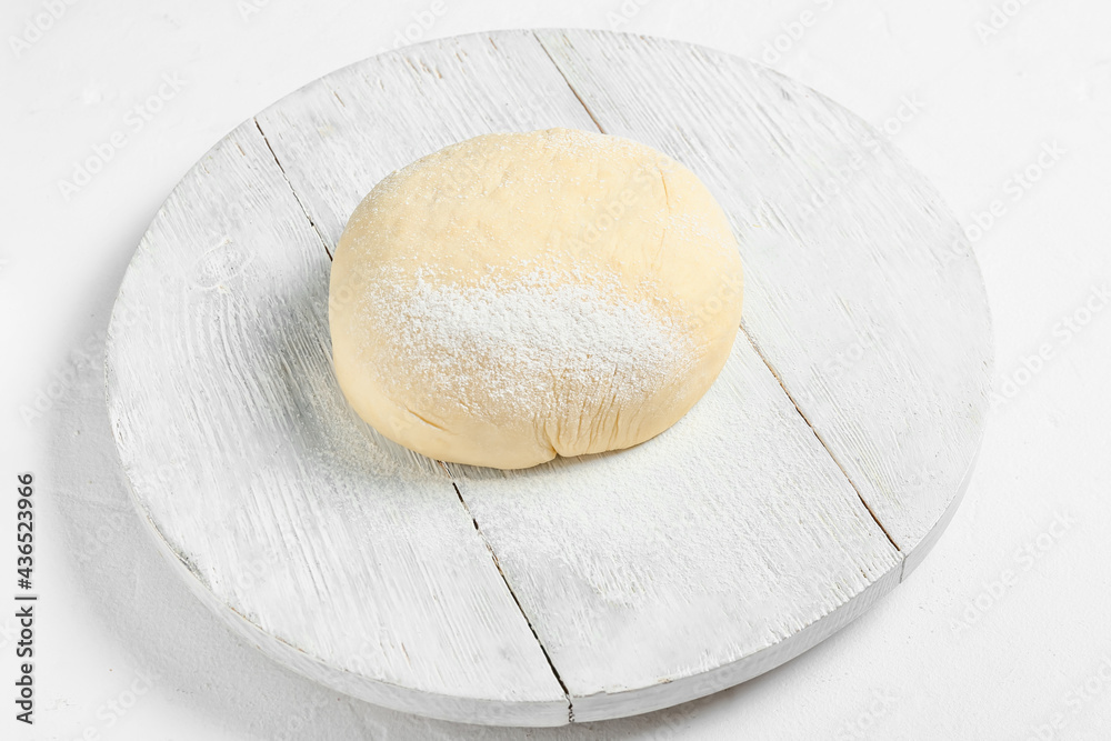Board with fresh dough and flour on white background Board with fresh dough and flour on white background