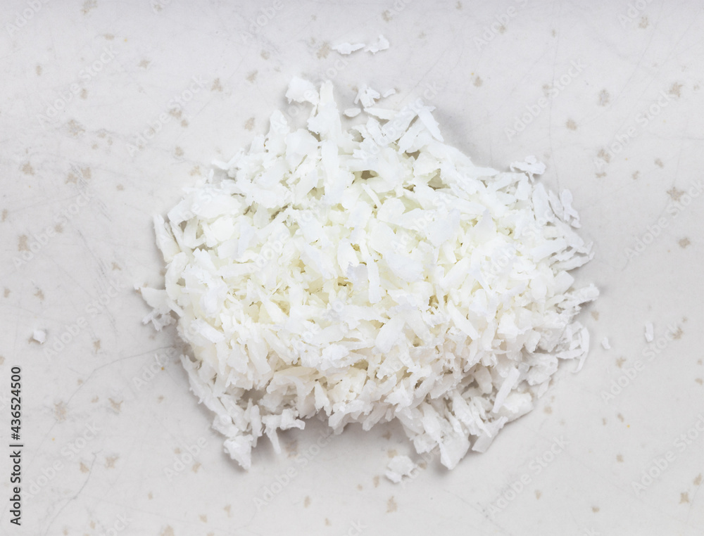 pile of coconut flakes close up on gray pile of coconut flakes close up on gray