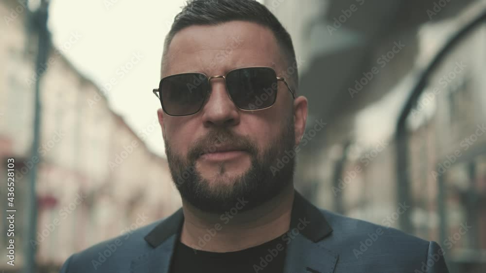 Young elegant male businessman in blue suit near office center waiting for business meeting.Portrait of a handsome bearded man. Young elegant male businessman in blue suit near office center waiting for business meeting.Portrait of a handsome bearded man.