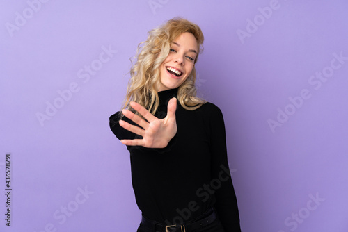 Young blonde woman isolated on purple background counting five with fingers