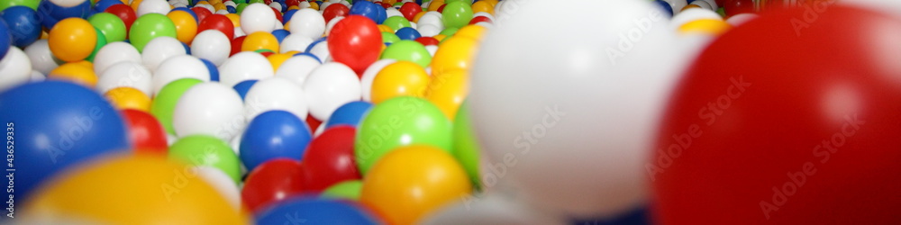A lot of colorful plastic balls closeup in perspective: red, green, blue, yellow colored wide background texture A lot of colorful plastic balls closeup in perspective: red, green, blue, yellow colored wide background texture