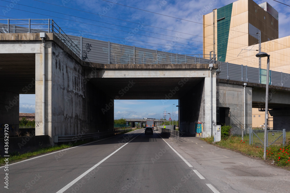 Italian state highway under bridge of the Emilia Romagna high-speed train