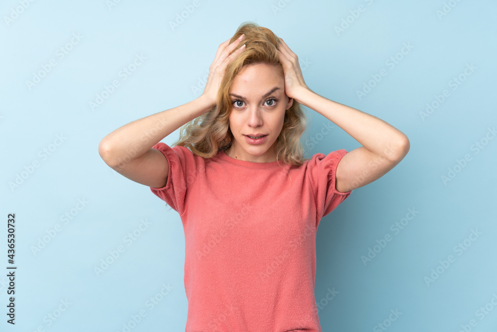 Young blonde woman isolated on blue background with surprise facial expression Young blonde woman isolated on blue background with surprise facial expression