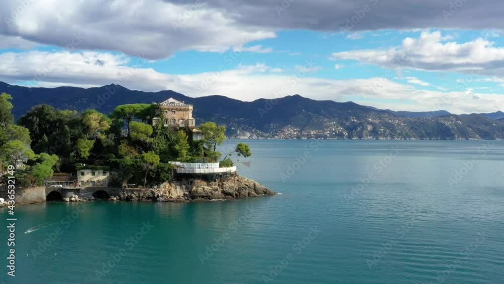 Panoramic view of the coast of Portofino in Italy. We can see the blue water near the houses and mountain under the blue sky 4K Panoramic view of the coast of Portofino in Italy. We can see the blue water near the houses and mountain under the blue sky 4K