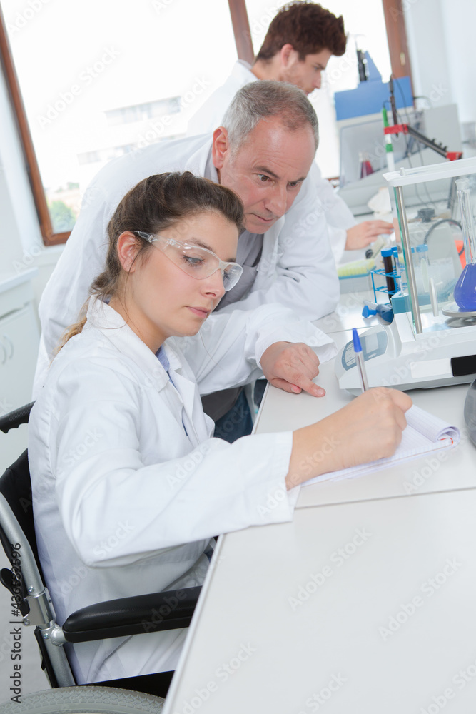 Obraz premium young female lab worker on wheelchair