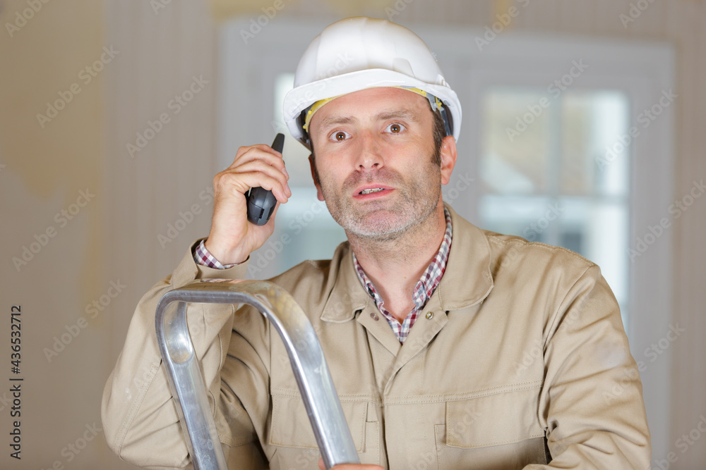 worried builder using a walkie talkie worried builder using a walkie talkie