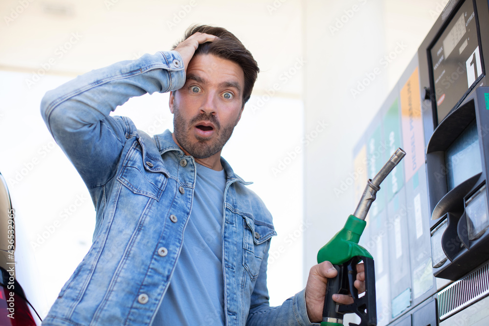 emotional businessman counting money with gasoline refueling car - obrazy, fototapety, plakaty 