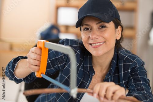 happy woman cutting cooper pipes photo