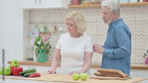 Senior Old Man Talking to Sad Senior Old Woman in Kictchen photo