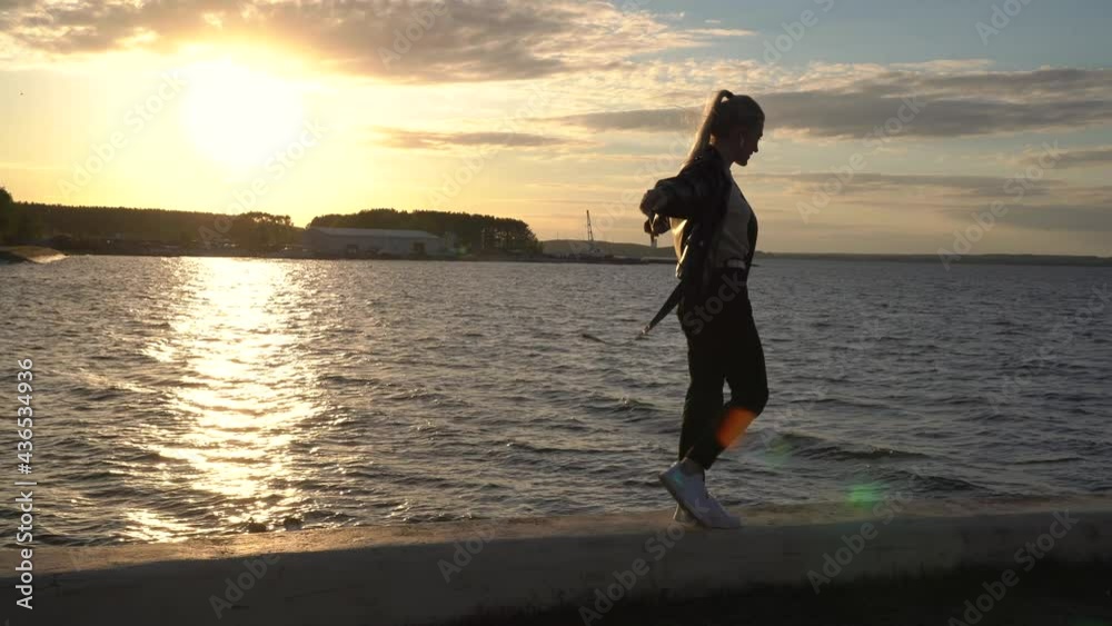 Beautiful girl walks on the parapet by the sea Beautiful girl walks on the parapet by the sea
