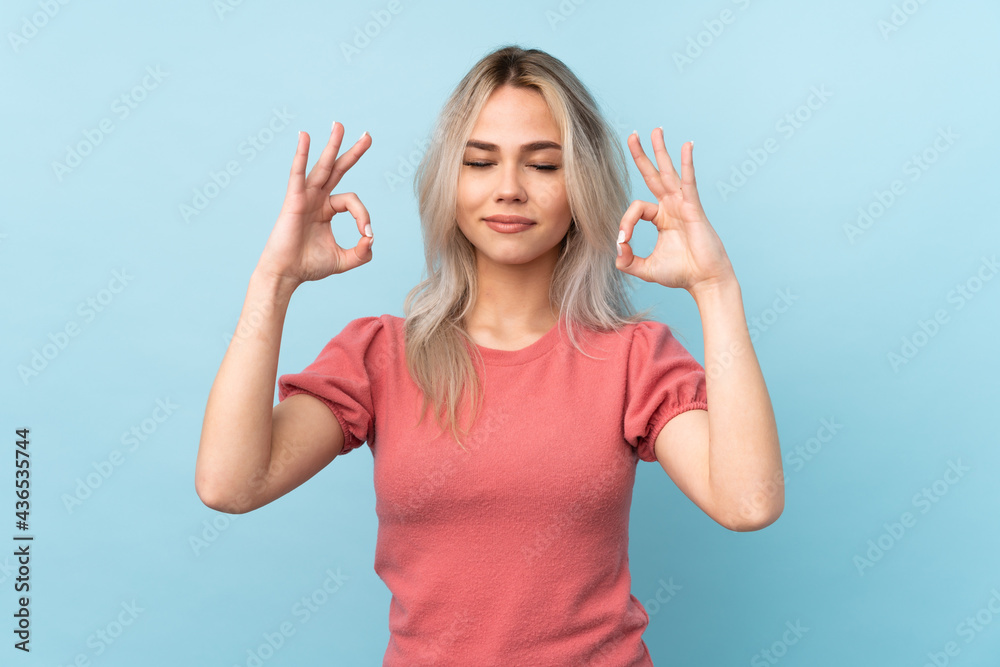 Teenager girl over isolated blue background in zen pose Teenager girl over isolated blue background in zen pose