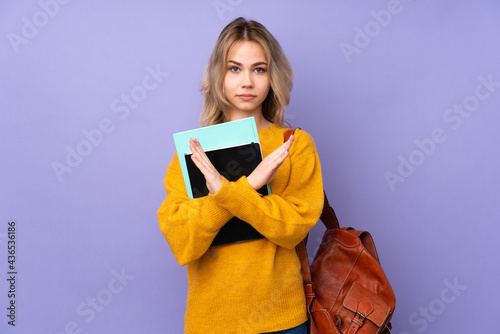 Teenager Russian student girl isolated on purple background making NO gesture
