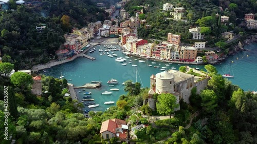 Wallpaper Mural The harbor of Portofino in italy with boats sailing in the water. We can see the city in the middle of forest and mountain near the water - aerial view 4K Torontodigital.ca