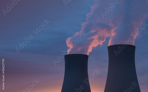 Nuclear power plant against sky at sunset