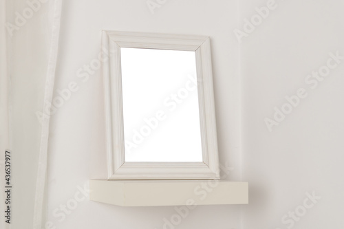 empty photo frame with a place to copy on a white shelf at home