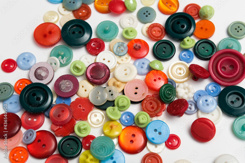 old plastic buttons in different colors on the background. old plastic buttons in different colors on the background.