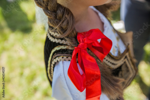 Serbian traditional folklore, red bow on little girl hair,closeup photo