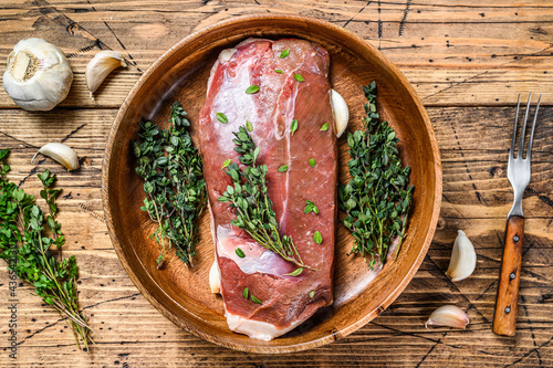 Raw uncooked poultry duck meat breast fillet with herbs. wooden background. Top view