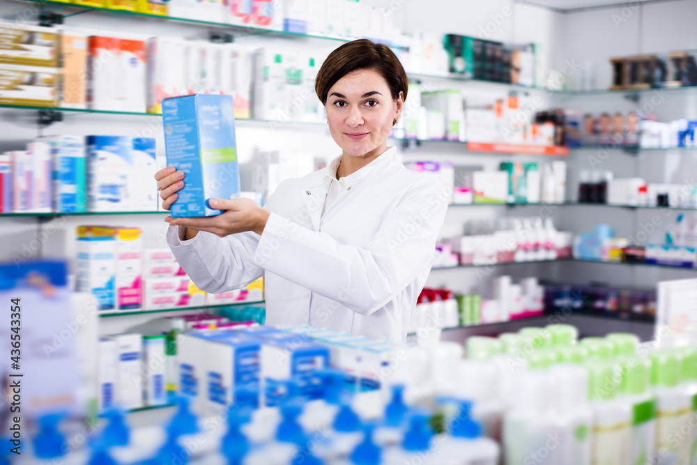 Smiling female offering reliable medicine in pharmacy
