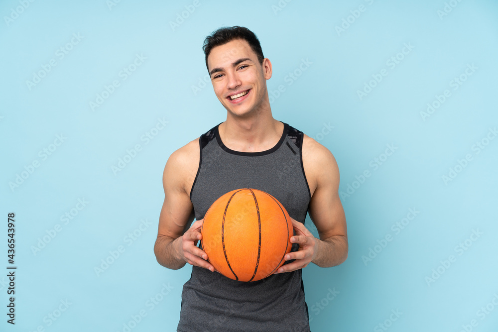 Man on isolated blue background playing basketball