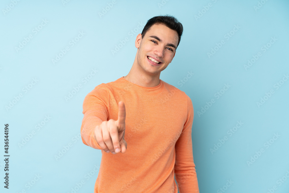 Young caucasian handsome man isolated on blue background showing and lifting a finger Young caucasian handsome man isolated on blue background showing and lifting a finger