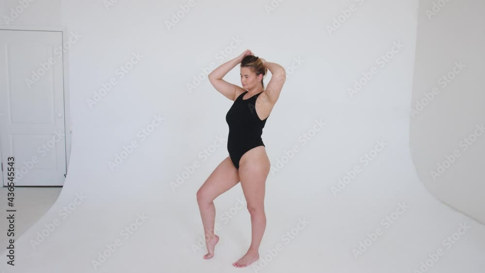 Beautiful overweight woman in black swimsuit on grey background Beautiful overweight woman in black swimsuit on grey background
