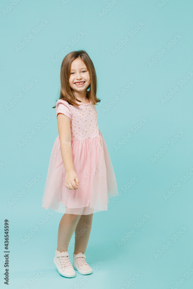 Full size body length little fun cute kid girl 5-6 years old wears pink dress dancing isolated on pastel blue color background child studio portrait. Mother's Day love family people lifestyle concept. Full size body length little fun cute kid girl 5-6 years old wears pink dress dancing isolated on pastel blue color background child studio portrait. Mother's Day love family people lifestyle concept.