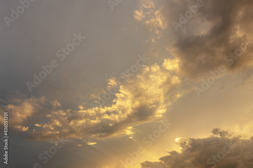 abstract background of beautiful cloudy sunset sky with sun rays golden hour