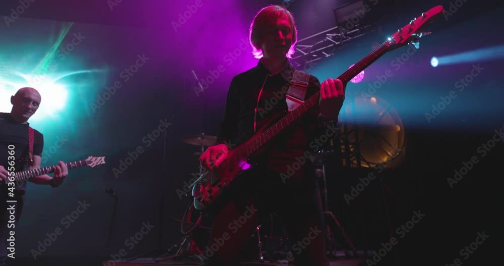 Live concert. Performance of a pop group, music band on stage. Stage light and bright flashes. Vocalist, guitarist. Slow motion Live concert. Performance of a pop group, music band on stage. Stage light and bright flashes. Vocalist, guitarist. Slow motion