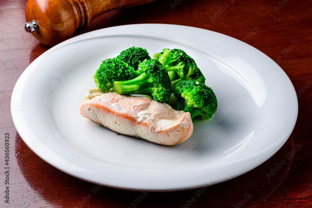 Steam salmon, broccoli, paleo, keto or fodmap diet. White plate on table Steam salmon, broccoli, paleo, keto or fodmap diet. White plate on table