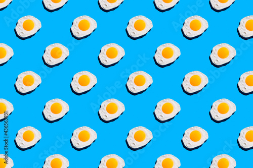 Fototapeta Naklejka Na Ścianę i Meble -  Fried egg pattern on bright blue background. Abstract background food pattern
