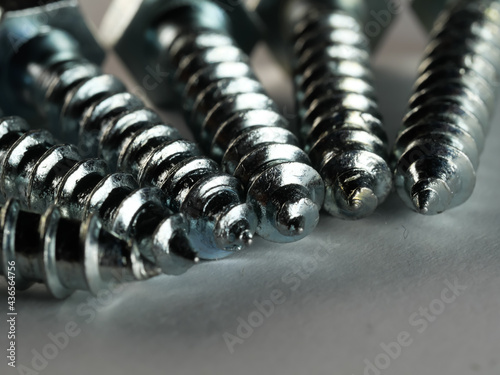 Closeup shot of lag screws on a gray surface photo