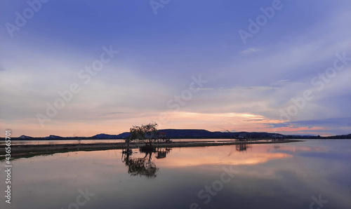 romantic sunset with countryside, Thai big fish trap common name Yor reflextion on the lake with cloudy sky in twilight time