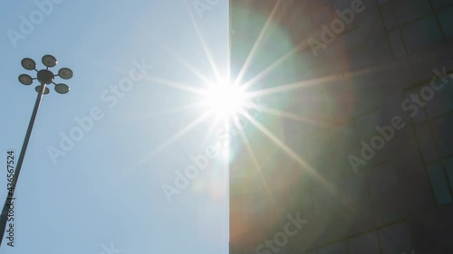 Time-lapse of sun beams and glass skyscraper wall. Daylight, sunny day, office building and sun moving in fast motion. Modern business district time-lapse