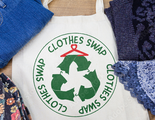 clothes swap roundel printed on reusable bag with clothes at clothes swap party, sustainable fashion photo