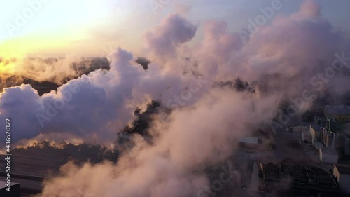 Estonia-November 25. 2019 Lots of white thick smoke in the sky of Imavere Estonia coming out from the big pipes of the buildings in the sawmill factory photo