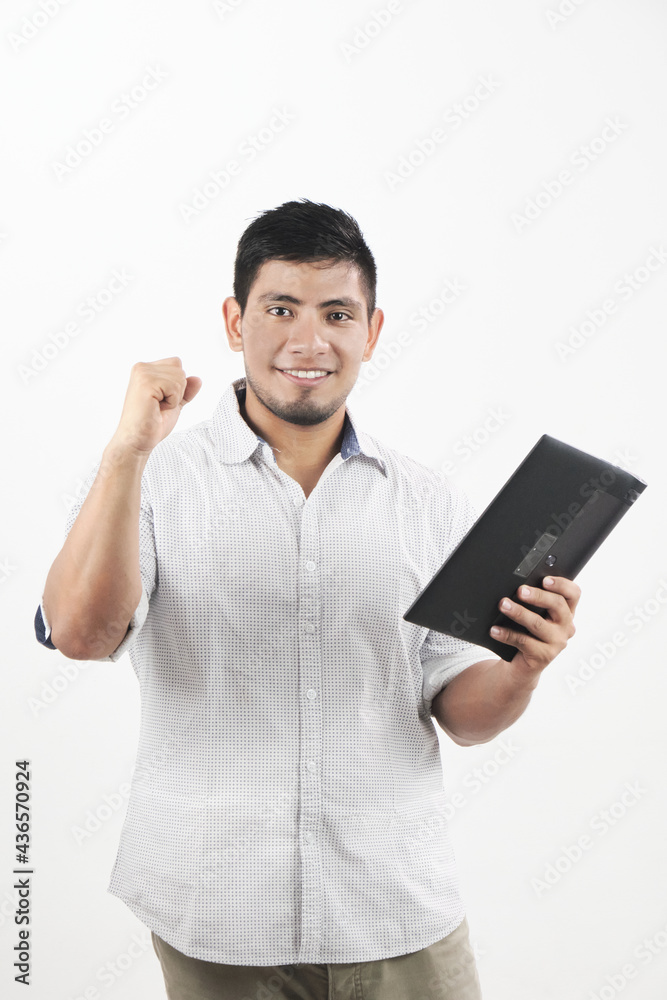 hombre latino sonriente con tableta en mano y levantando el puño de manera victoriosa hombre latino sonriente con tableta en mano y levantando el puño de manera victoriosa