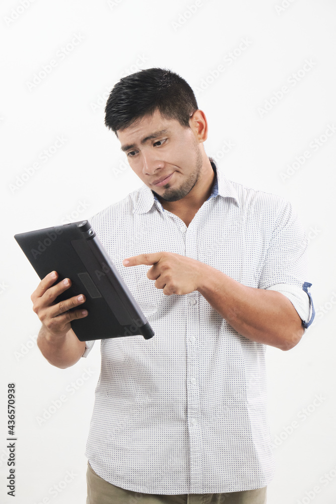 hombre latino sonriente revisa su tableta con actitud de preocupación hombre latino sonriente revisa su tableta con actitud de preocupación