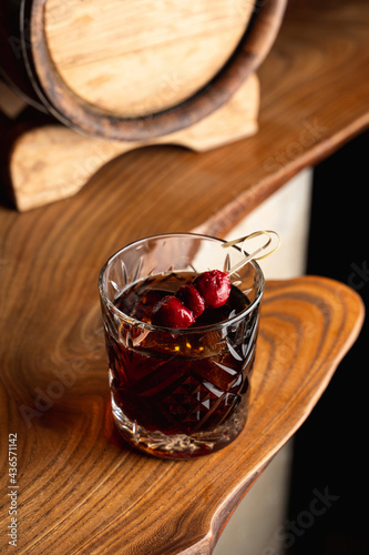Posh cherry cocktail with rum in an old fashioned style glass, reflection on a bar counter