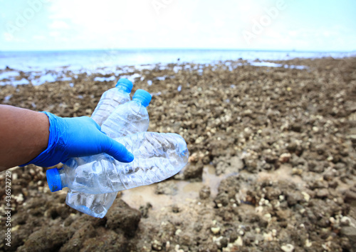 lose up Volunteer hand wearing glove collect the rubbish from coral field at beach of sea