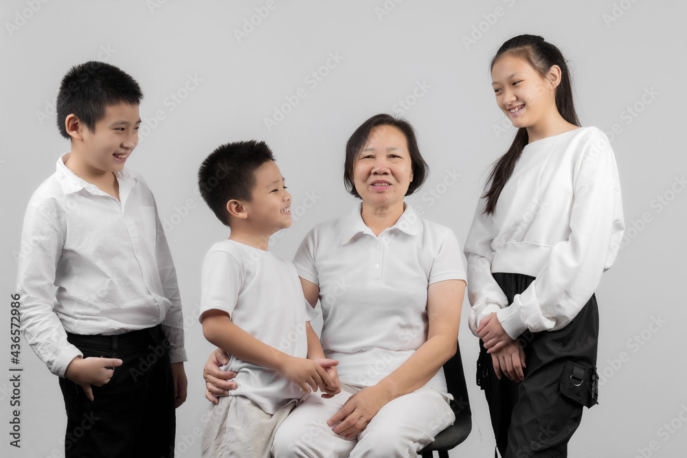 Portrait of Grandmother and grandchild hugging, looking at camera and smiling, on gray background Portrait of Grandmother and grandchild hugging, looking at camera and smiling, on gray background
