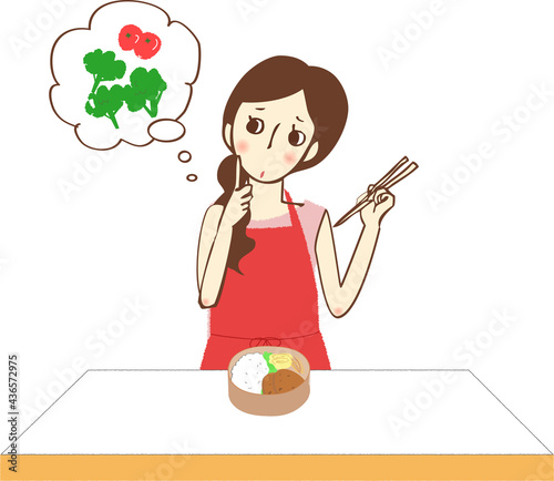 お弁当の隙間に何を入れようか考えるエプロン姿の女性。