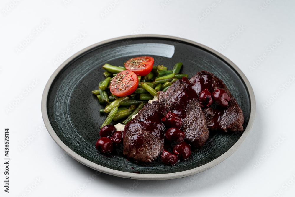 Beef steak with sweet cherry sauce, isolated on white studio background Beef steak with sweet cherry sauce, isolated on white studio background