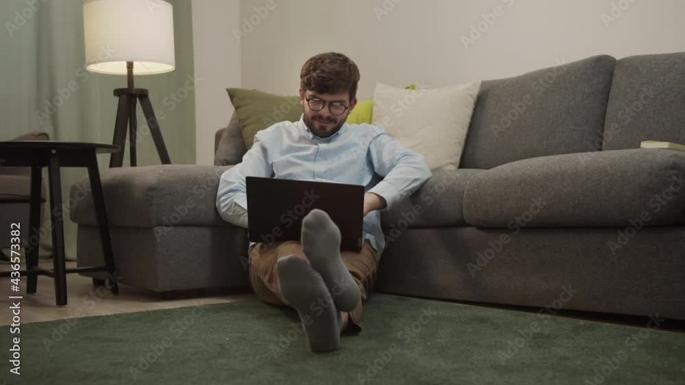A white man communicates by video link while sitting on the floor A white man communicates by video link while sitting on the floor
