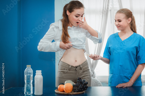 Female Doctor is Consulting and Advise to Patient About Nutrition for Health. Nutritionist Female Doctor is Showing a Glass of Milk to Camera, Vitamin Nutients From Vegetables for Healthy Eating. photo