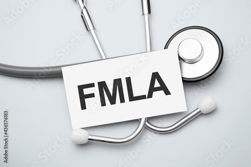 Paper with Family Medical Leave Act FMLA on a table and grey stethoscope photo