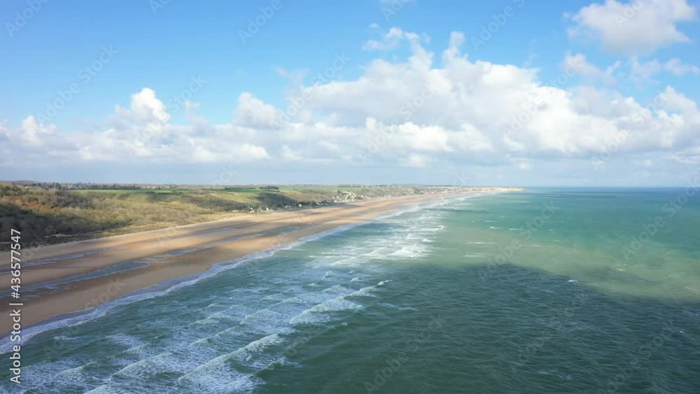 La plage du débarquement de Omaha beach dominée par ses immenses falaises en France, en Normandie, dans le Calvados, au bord de la Manche, au printemps.