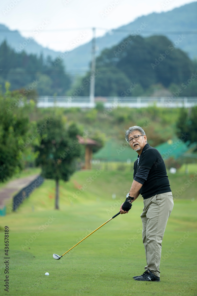 Obraz premium ゴルフを楽しむシニア男性