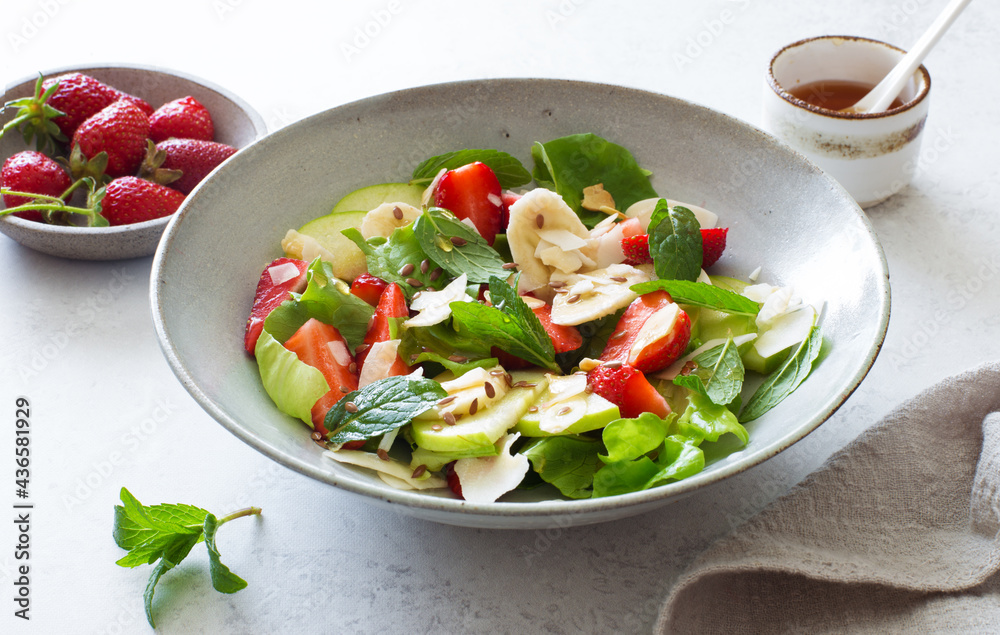 Ripe strawberries, apples, bananas, coconut and mixed salad leaves healthy salad Ripe strawberries, apples, bananas, coconut and mixed salad leaves healthy salad